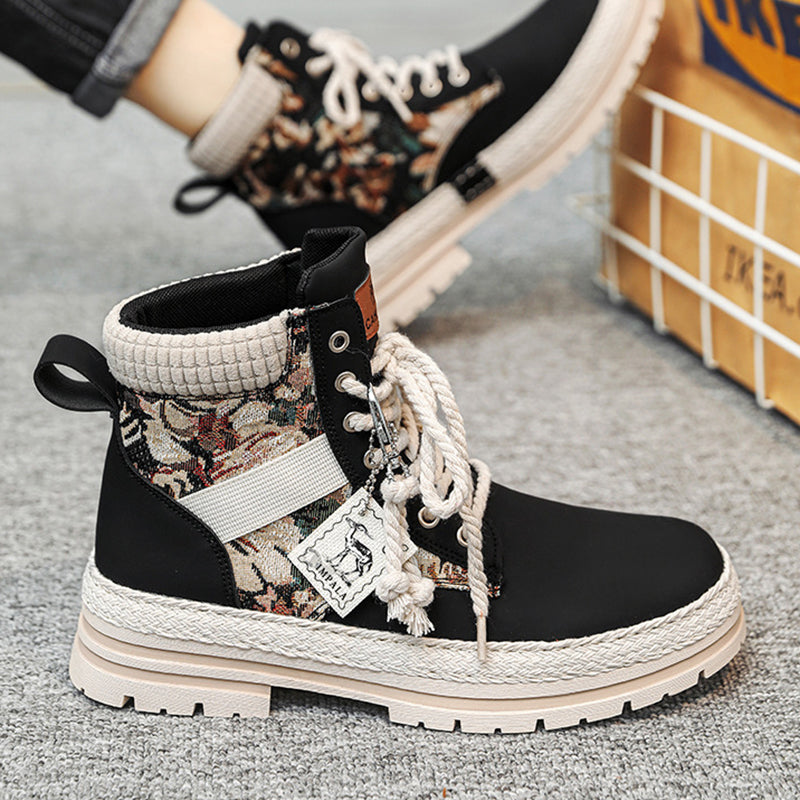 Black and floral-patterned boot with white laces on a gray surface