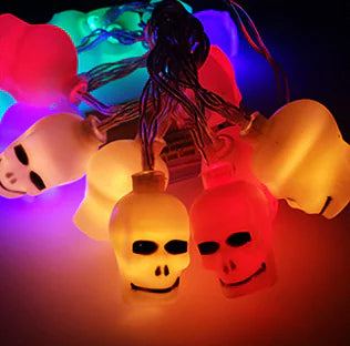 String lights shaped like pumpkins and skulls on a dark background