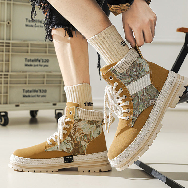 Person wearing camouflage-patterned boots with a neutral background