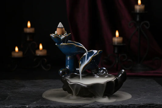 Ceramic incense burner with blue and gold design on a textured surface