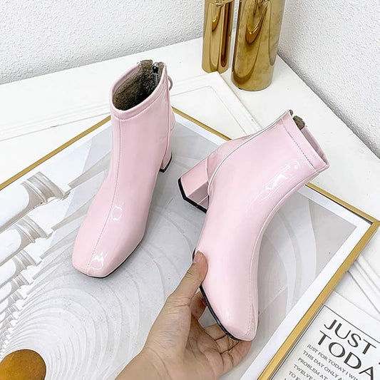 Pink high-heeled shoes on a white surface with a gold frame.