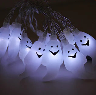 String of ghost-shaped lights with smiling faces on a dark background