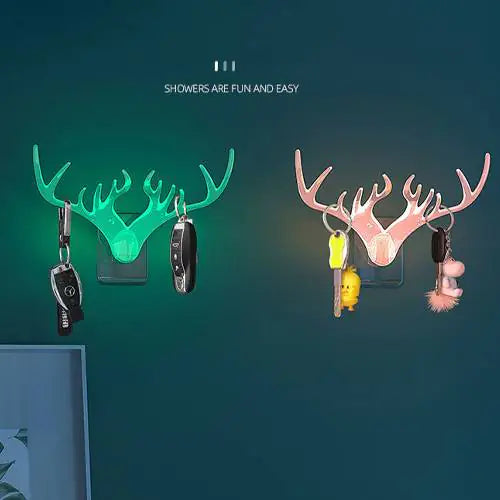 Two wall hooks with deer antler design on a dark green background.