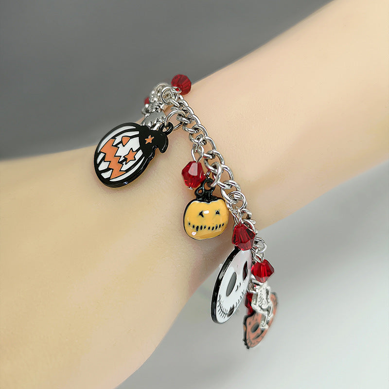 Bracelet with Halloween-themed charms on a wrist against a neutral background
