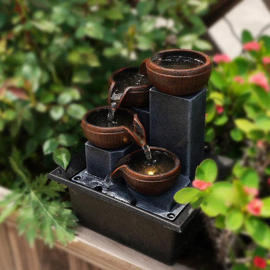 Small water fountain with terracotta pots in a garden setting