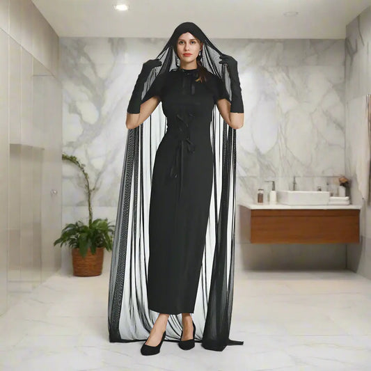 Person wearing a black dress with a sheer black veil on a white background