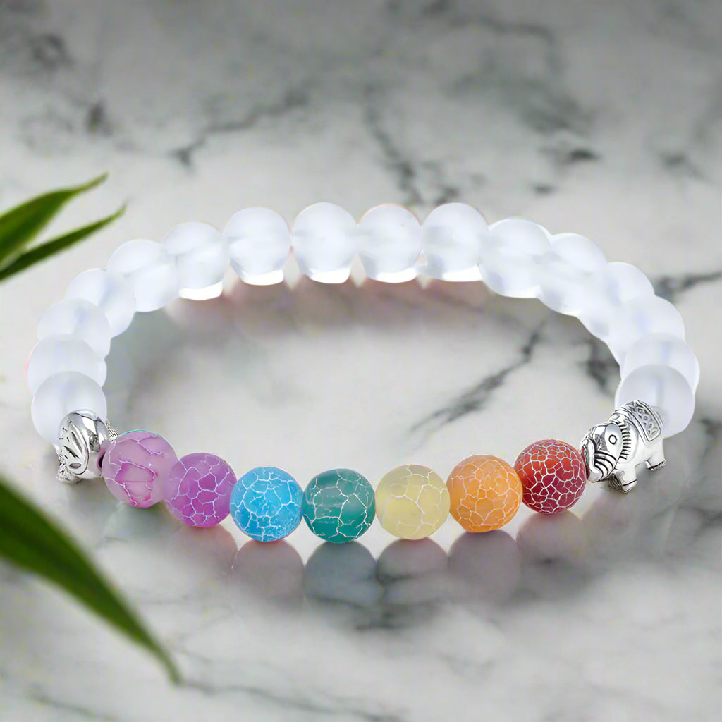Bracelet with white beads and colorful beaded charm on a white background