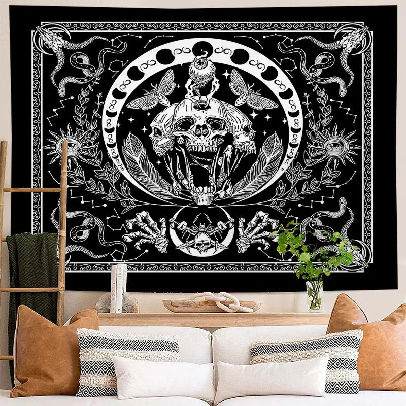 Decorative tapestry with skull and snake design on a wall above a sofa.