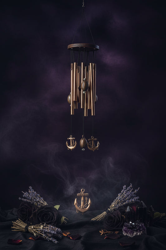 Decorative wind chime with anchor design on a white background