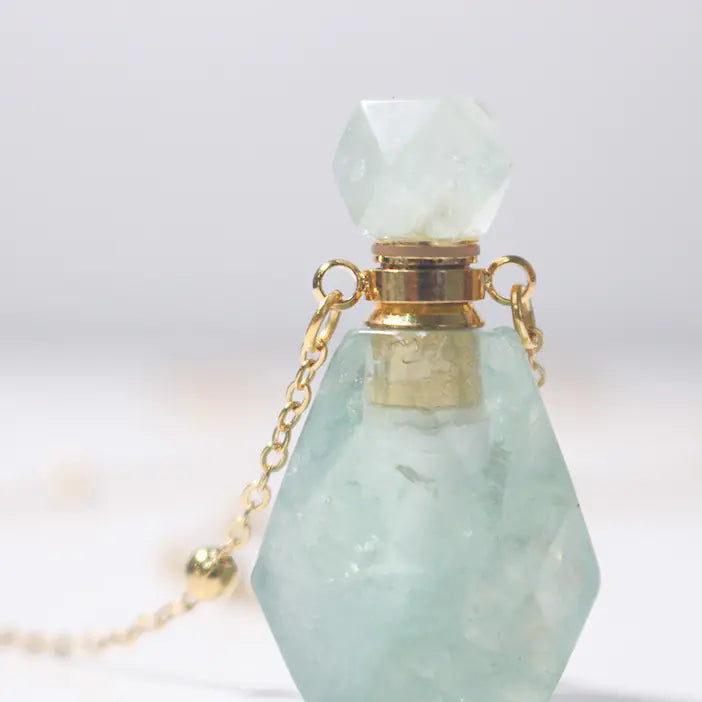 Crystal bottle with gold cap and chain on a white background