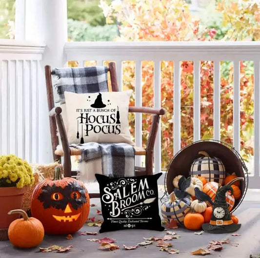 Halloween-themed decor with pumpkins, pillows, and decorative items on a porch.