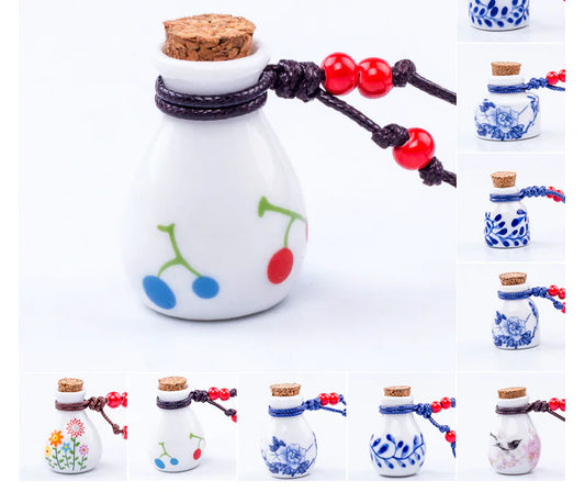 Set of small decorative bottles with cork lids and colorful necklaces on a white background