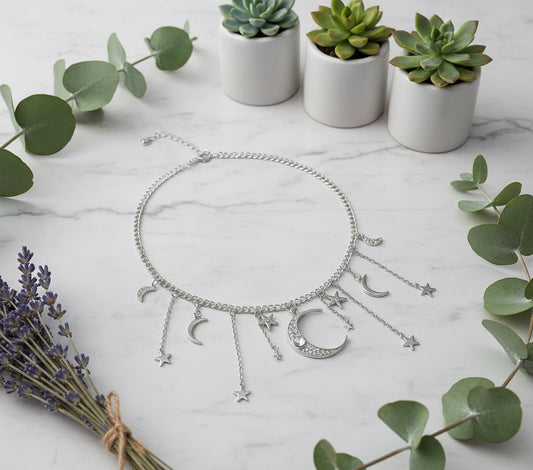 Silver necklace with moon and star charms on a black background