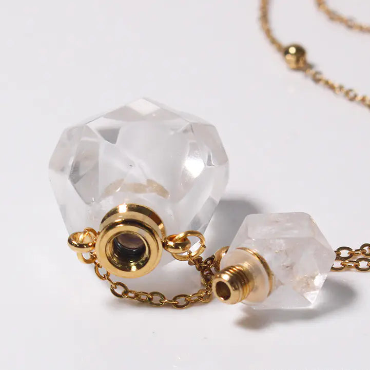 Close-up of a crystal necklace with gold chain on a white background