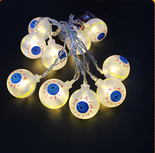 String of light bulbs shaped like eyeballs with blue irises on a black background