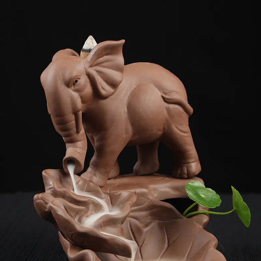 Ceramic elephant incense burner with incense smoke on a dark background