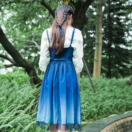 Person wearing a blue dress with a white blouse in a forest setting