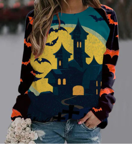 Halloween-themed sweatshirt with haunted house and bats design, worn by a person.