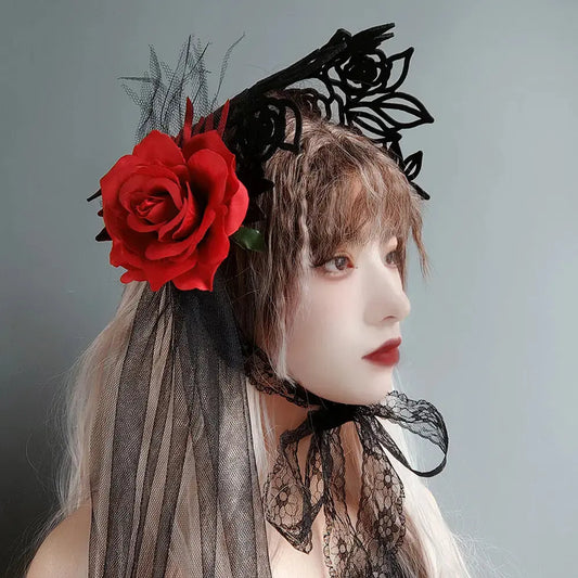 Person wearing a black lace headpiece with a red rose against a gray background
