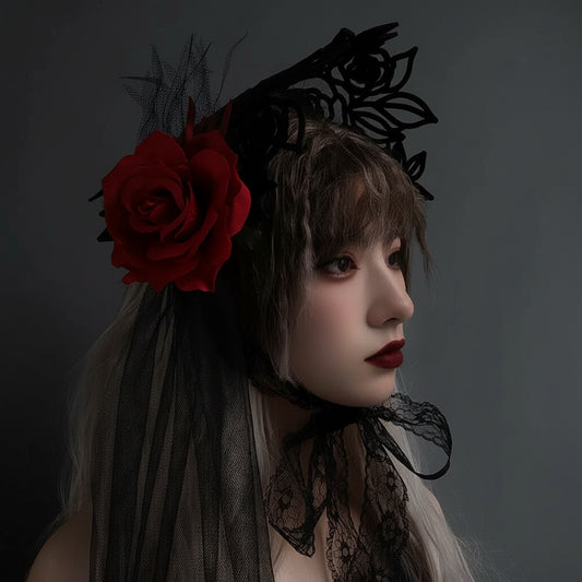 Person wearing a black lace headpiece with a red rose against a gray background