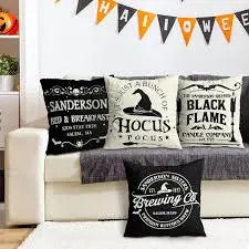Decorative Halloween pillows on a couch with a festive banner above.