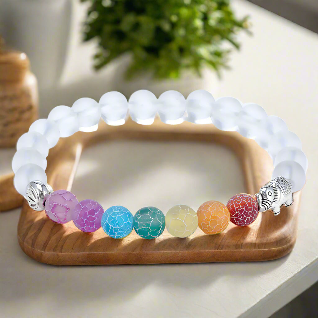 Bracelet with white beads and colorful beaded charm on a white background