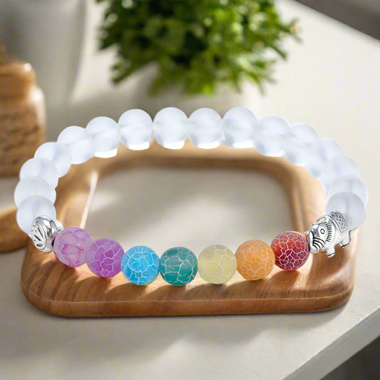 Bracelet with white beads and colorful beaded charm on a white background