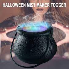 Halloween mist maker fogger with colorful mist being emitted, used by a person.