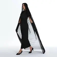 Woman wearing a long black and white lace cloak dress on a white background
