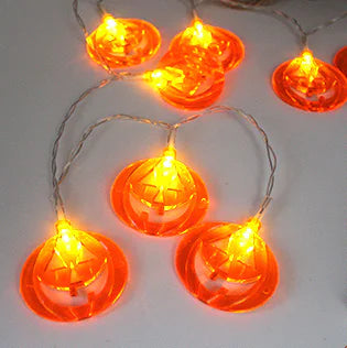 String lights shaped like jack-o'-lanterns on a white background