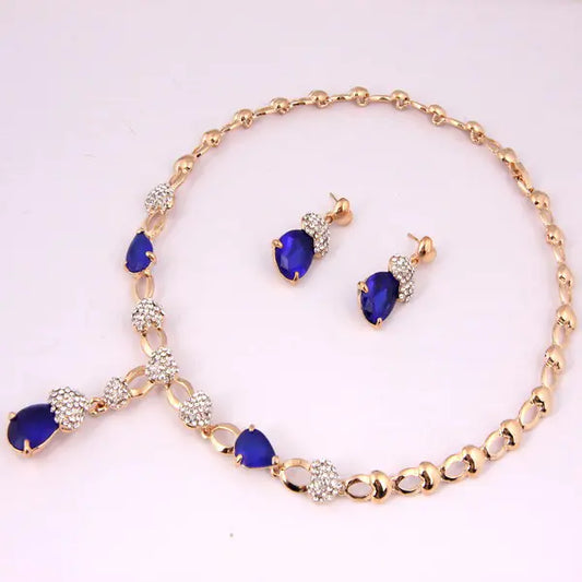 Jewelry set with blue gemstones and gold accents on a white background