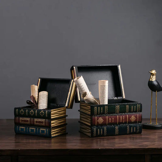 Decorative book-shaped boxes with open lids on a wooden surface against a dark gray background