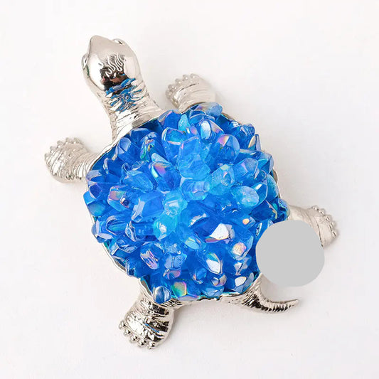 Decorative turtle figurine with blue bead shell on a white background