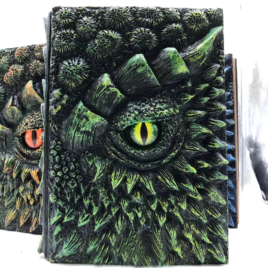 Book with a dragon design on the cover, featuring green scales and eye.