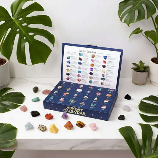 Advent calendar with crystal gems and a hand holding a green gemstone.