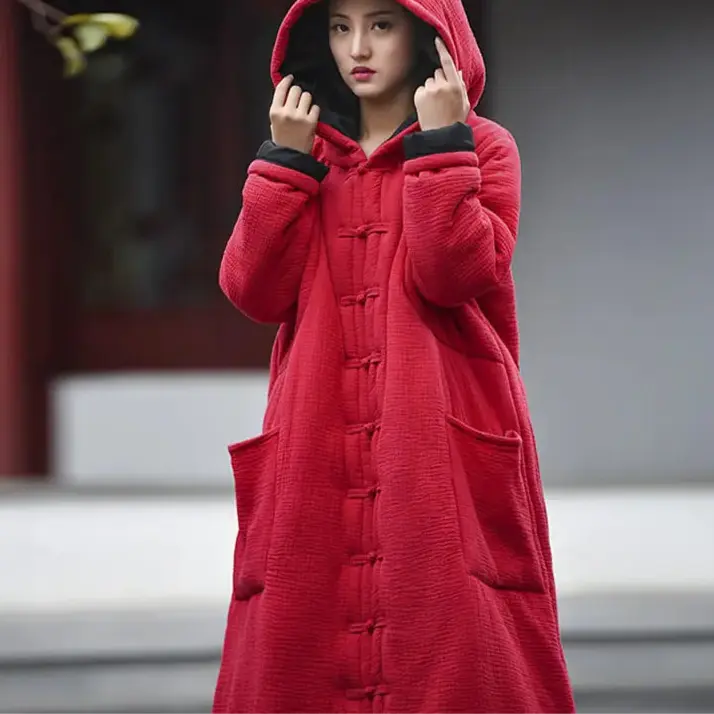 Person wearing a red hooded coat with a blurred background