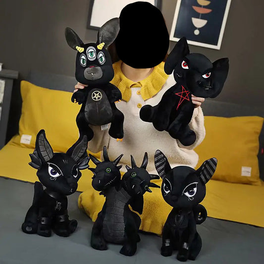 Woman holding black plush toys with unique designs on a yellow couch.