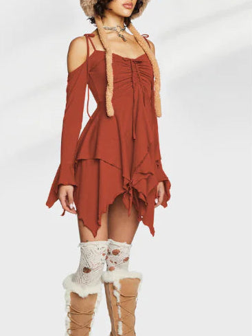 Woman wearing a rust-colored dress with long sleeves and lace details, paired with beige knee-high boots on a white background.