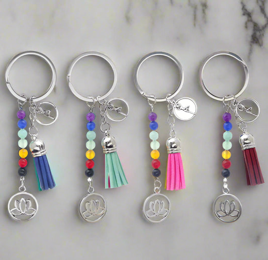 Set of four keychains with colorful beads and tassels on a white background