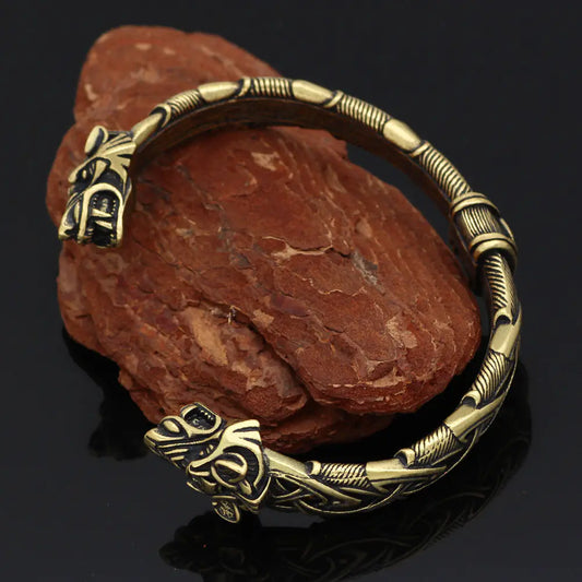 Bronze bracelet with intricate designs on a dark background