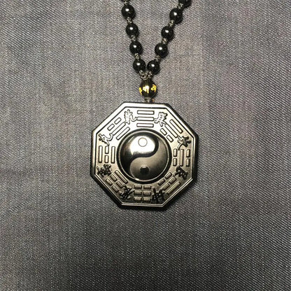 Pendant with yin yang symbol on a gray fabric background