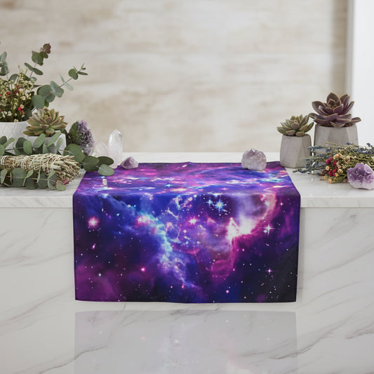 Galaxy tapestry hanging on a wall with a small table and decor items below.