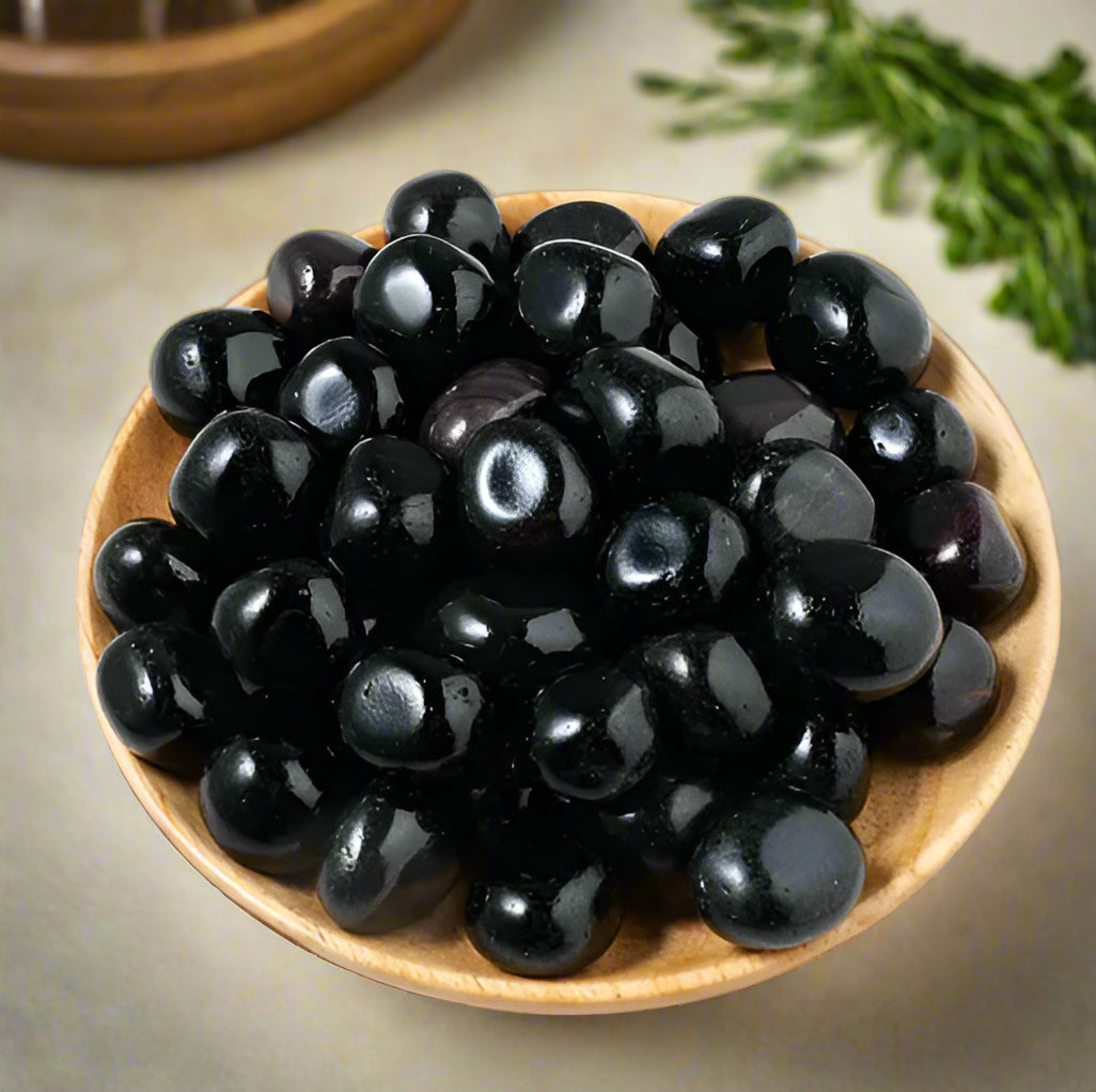 wooden bowl of obsidian crystals for witchcraft supplies