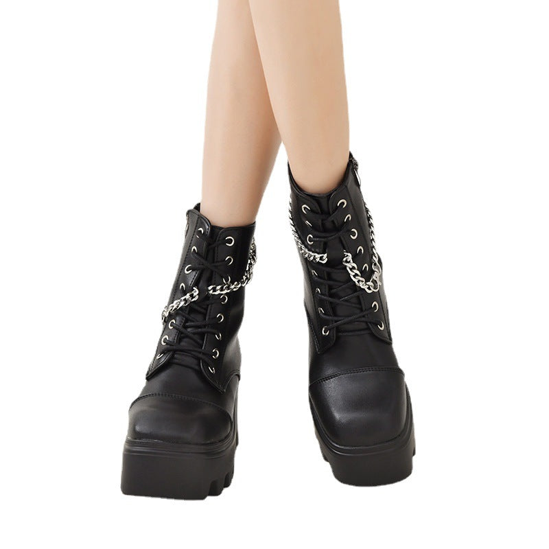 Black leather boots with chain details on a white background