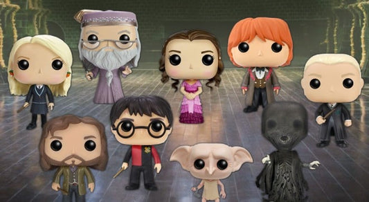 Collection of Harry Potter-themed figurines on a wooden floor background