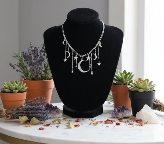 Necklace with moon and star charms on a black stand