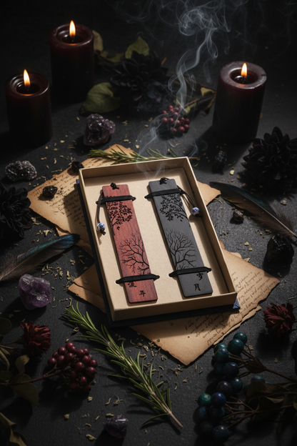 Two wooden bookmarks with tree designs in a box on a textured surface.