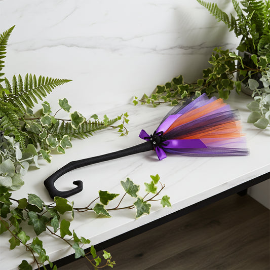 Halloween-themed decorative cane with a colorful tutu skirt and purple bow on a white background
