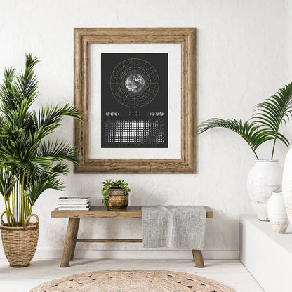 Framed black and white poster on a wall with plants and a wooden bench in a room.