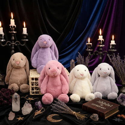 Five plush bunny toys in different colors on a wooden surface with a decorative wall background.